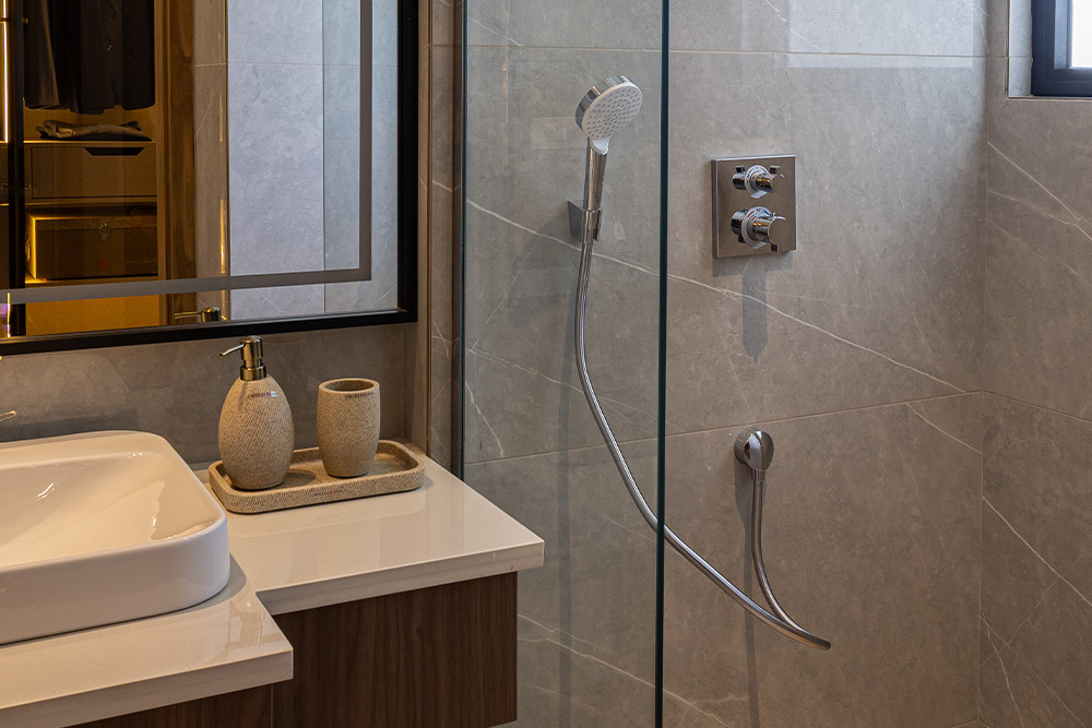 Contemporary Casa Homes bathroom featuring a glass-enclosed shower, matte black fixtures, and textured ceramic wall tiles for a sleek, modern vibe