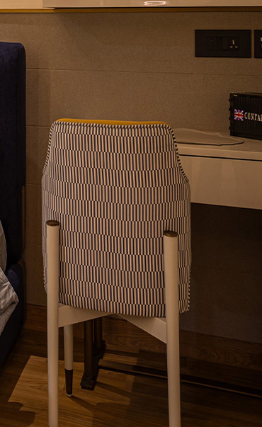 Casa Homes modern bedroom with a serene beige and wood-toned palette, featuring a mint green bed, warm ambient lighting, and a stylish lounge chair