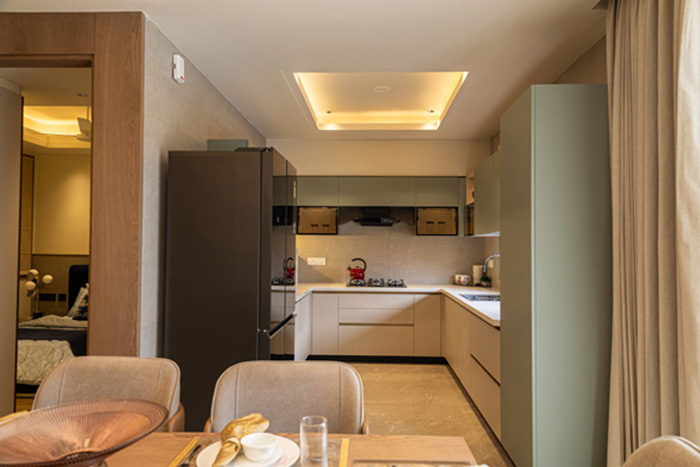 Modern Casa Homes kitchen with matte white cabinets, a central island featuring wood finish, built-in oven, and minimalistic lighting for a sleek, contemporary look.